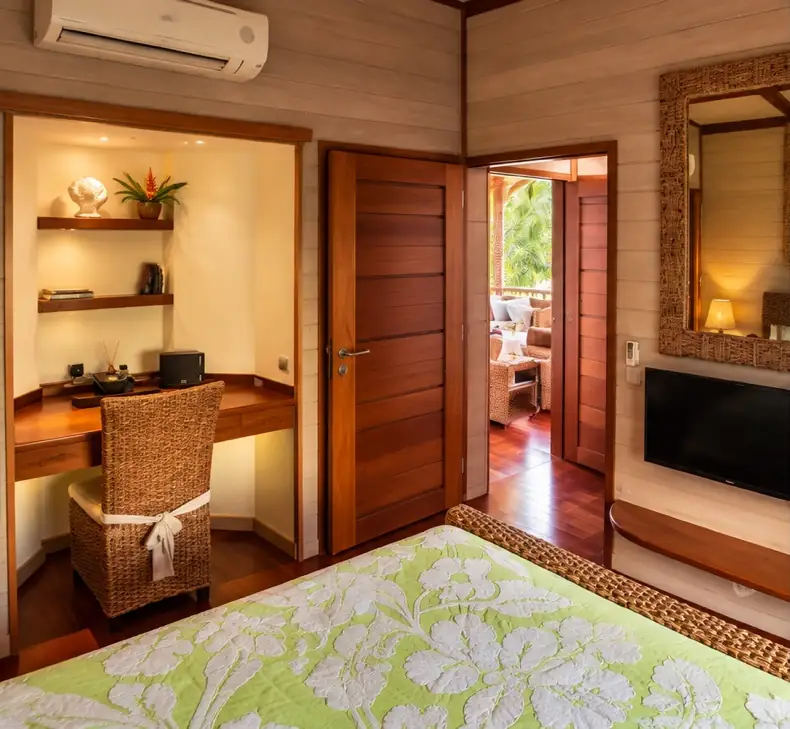 Chambre avec bureau en bois et porte ouverte sur le salon