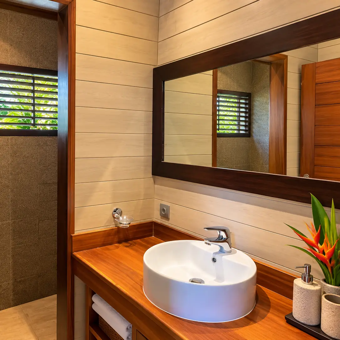 Salle de bain avec douche, vasque ronde et miroir encadré de bois