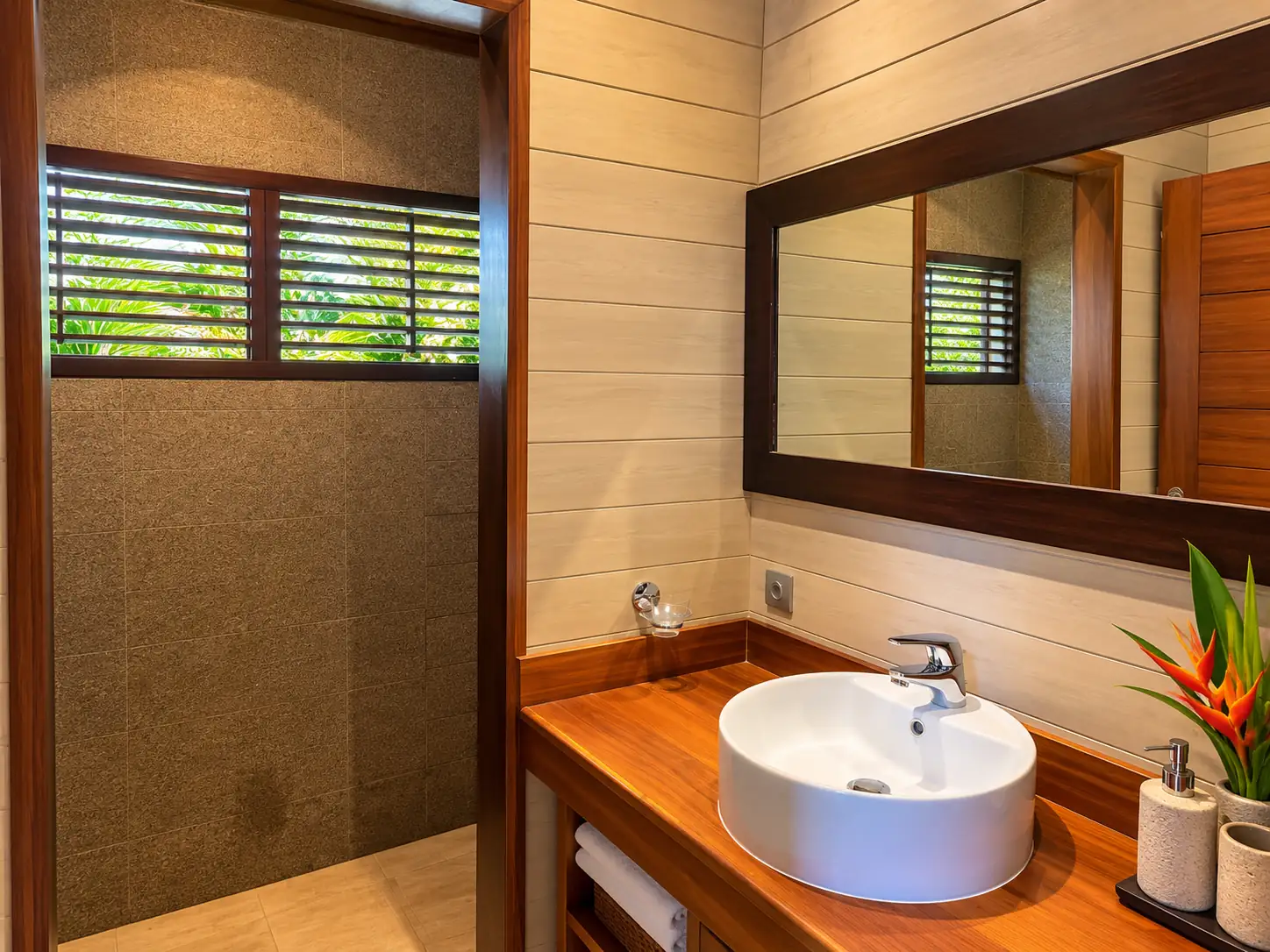 Salle de bain avec douche, vasque ronde et miroir encadré de bois